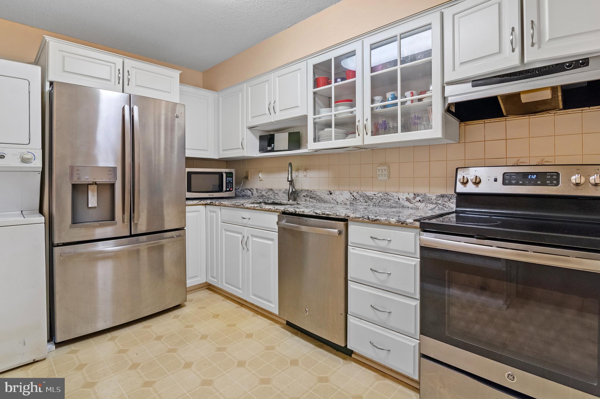 15115 Interlachen Drive, Unit 3506 Silver Spring, MD 20906 - Photo 9 of 27 a kitchen with granite countertop cabinets stainless steel appliances and a counter space