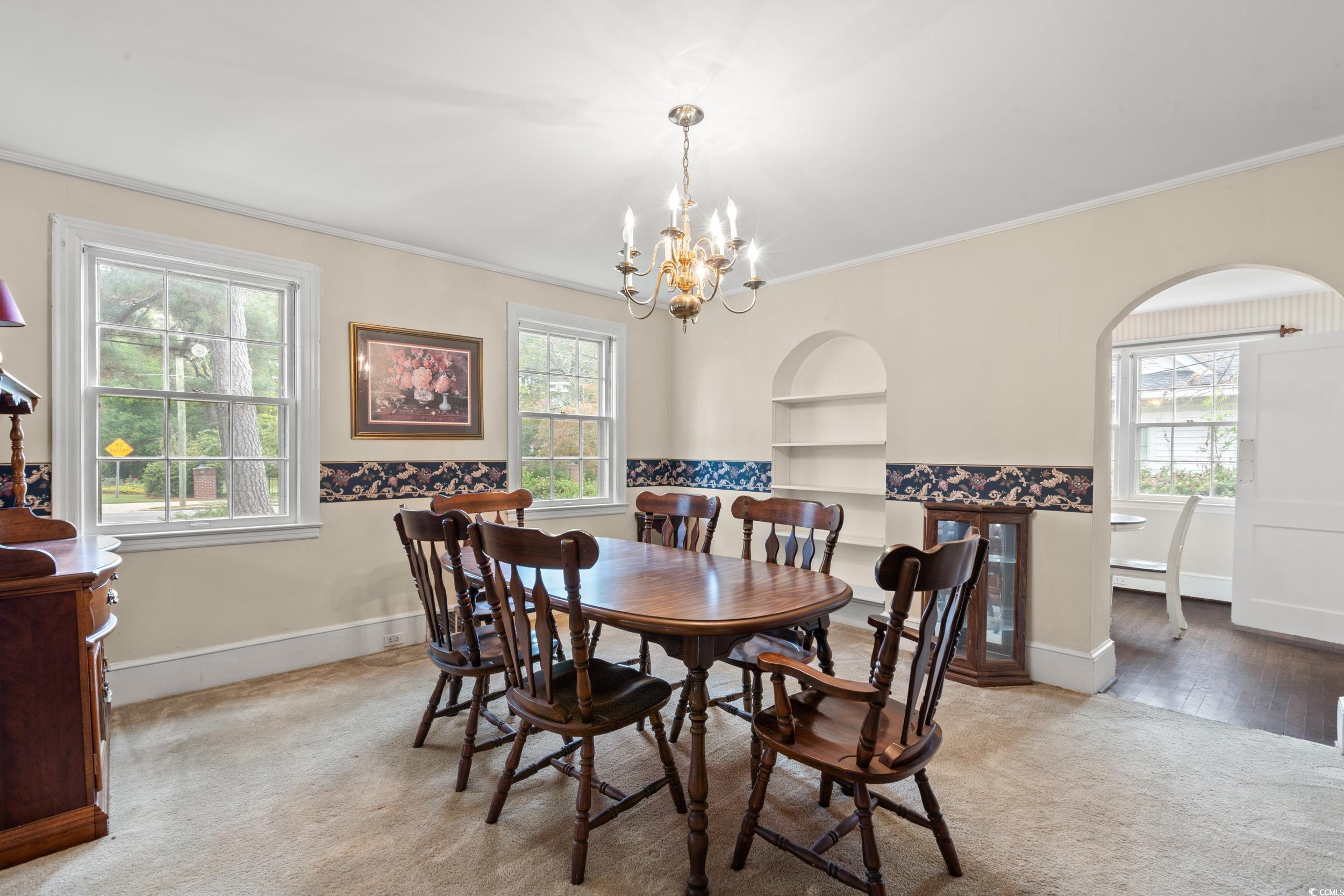 310 North Main Street Mullins, SC 29574 - Photo 29 of 35 Dining room featuring carpet, built in features, a chandelier, and crown molding