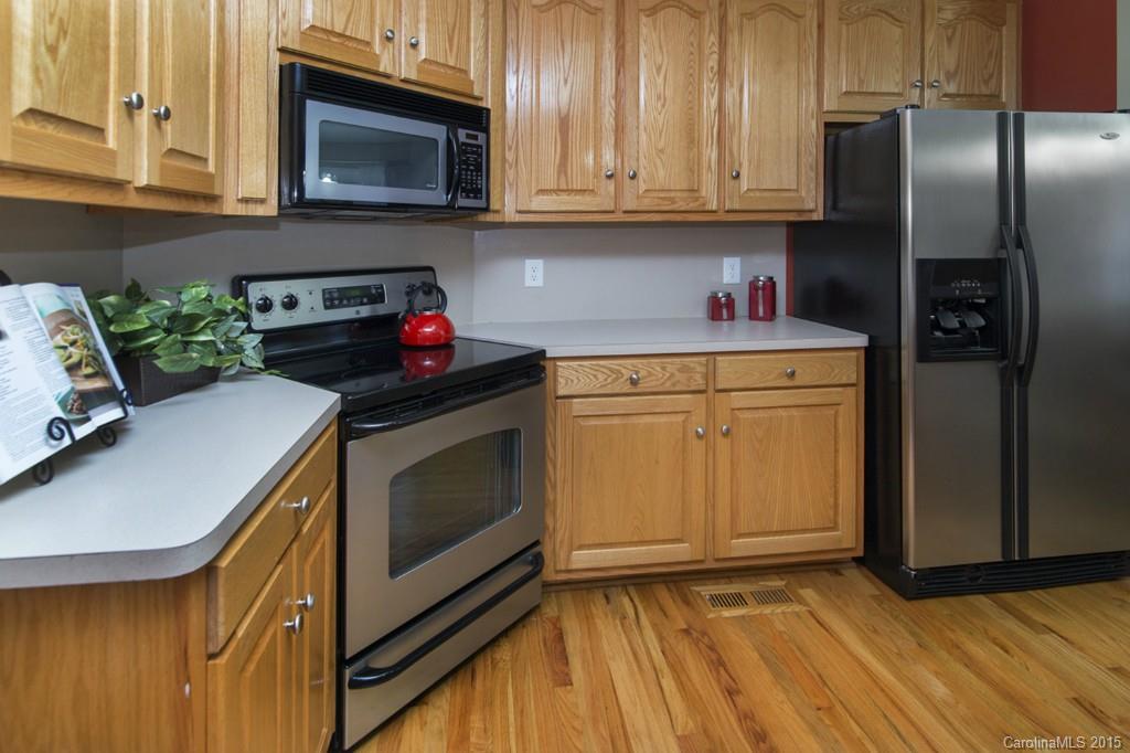 3474 Mack Ballard Road Maiden, NC 28650 - Photo 6 of 24 a kitchen with stainless steel appliances granite countertop a refrigerator stove and sink with wooden floor