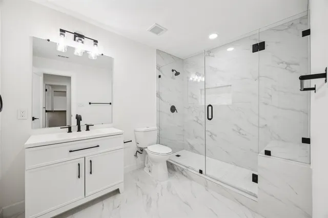 a bathroom with a double vanity sink mirror and toilet