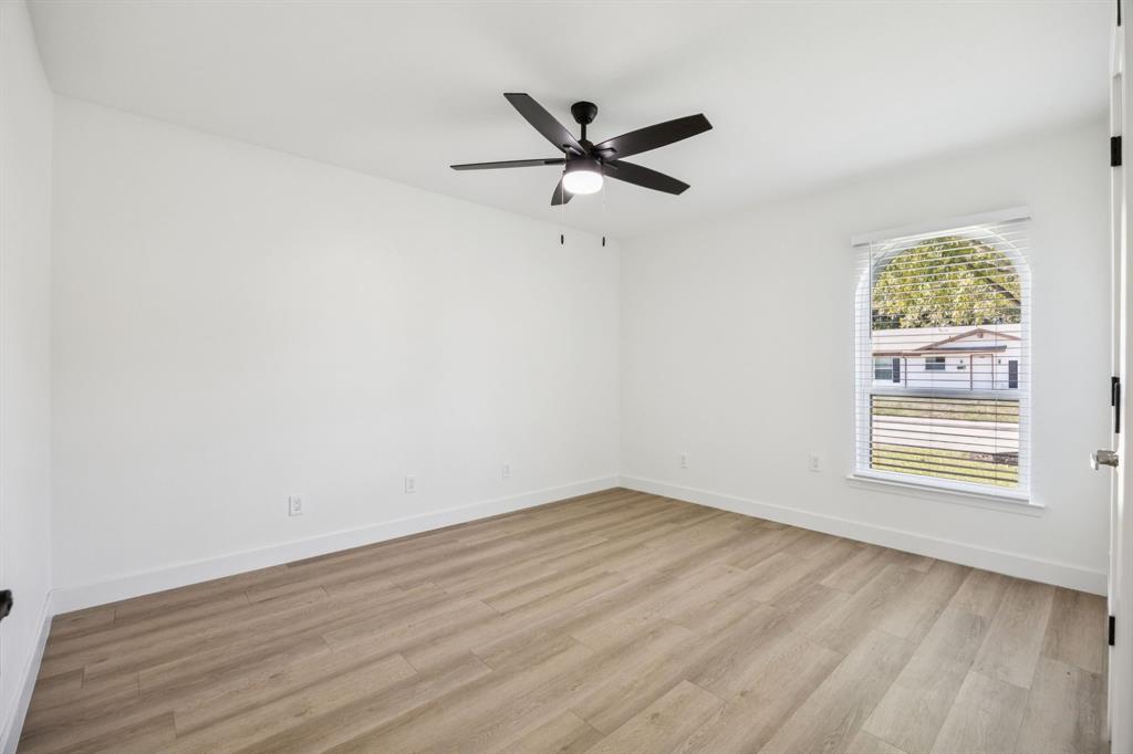 2516 Sunridge Road Carrollton, TX 75006 - Photo 24 of 39 an empty room with wooden floor fan and windows