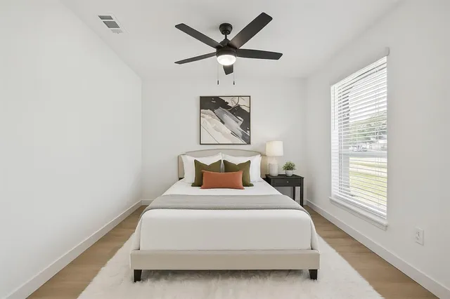 a bedroom with a bed and window with a chandelier