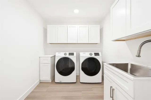 a utility room with sink dryer and washer
