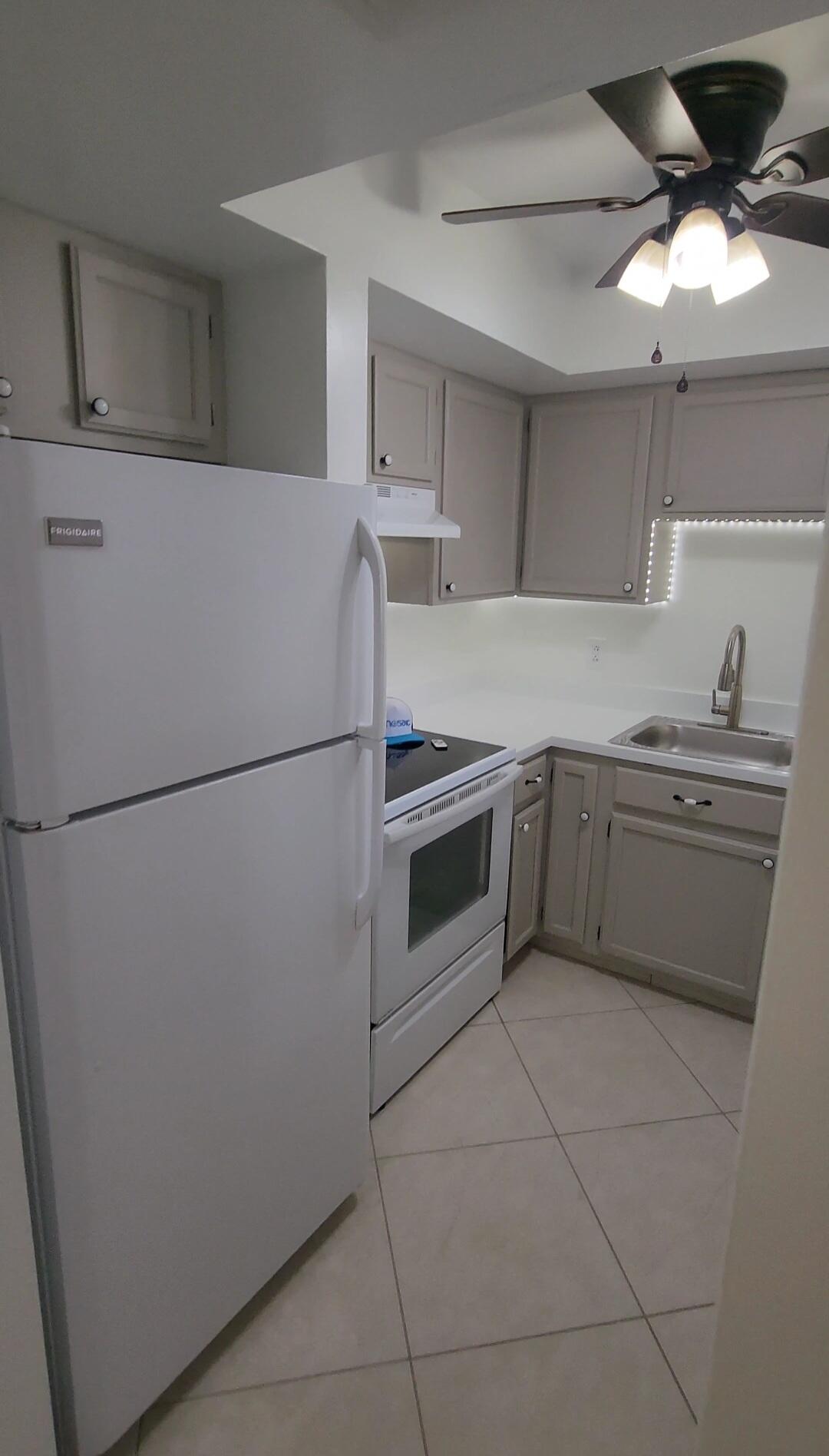 105 South Riverside Drive, Unit 302 Pompano Beach, FL 33062 - Photo 15 of 37 a kitchen with a sink a stove and a refrigerator