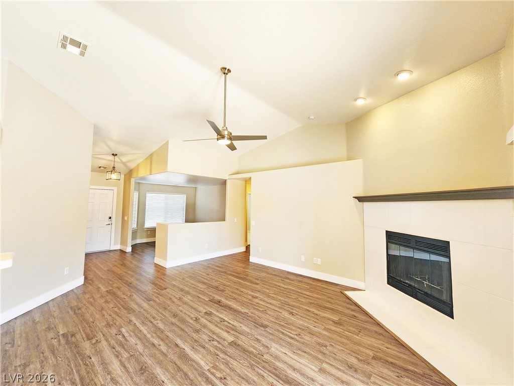 4591 Stoneham Street Pahrump, NV 89061 - Photo 5 of 42 A spacious living area with vaulted ceilings and a modern fireplace offers comfort.
