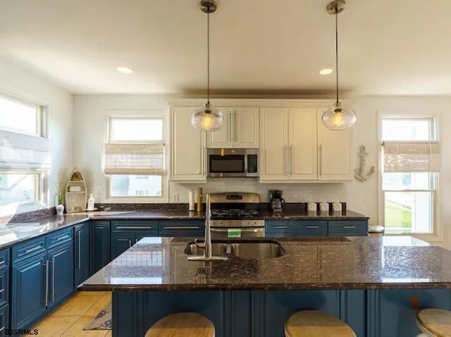 a kitchen with stainless steel appliances granite countertop a sink a window and kitchen island