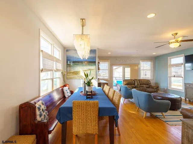 a living room with furniture kitchen view and a large window