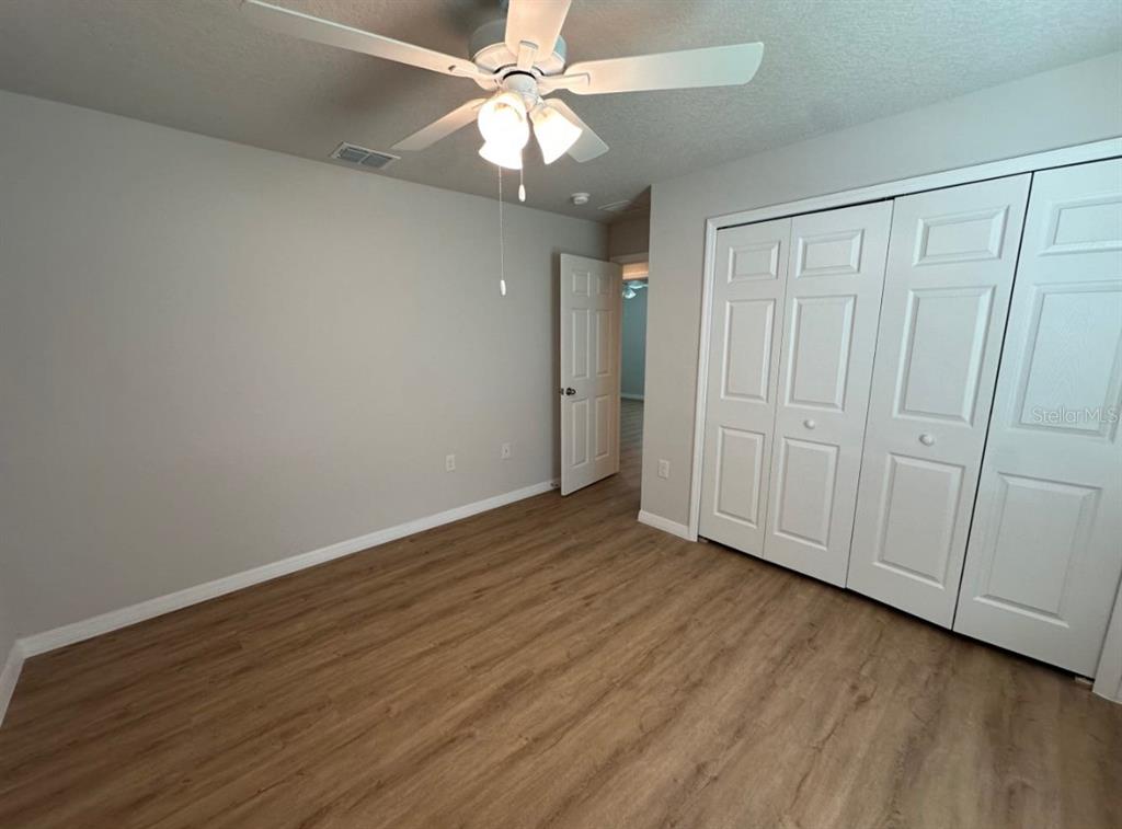 2467 Zuyder Terrace North Port, FL 34286 - Photo 4 of 14 an empty room with wooden floor fan and windows