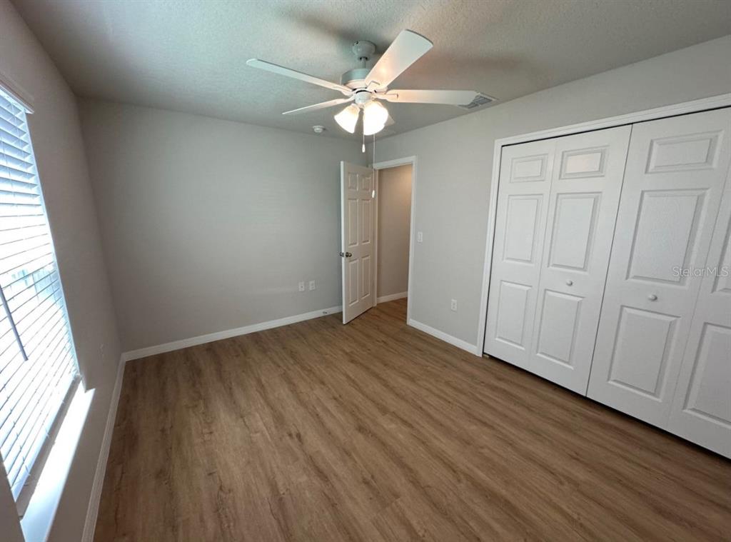 2467 Zuyder Terrace North Port, FL 34286 - Photo 6 of 14 an empty room with wooden floor fan and windows