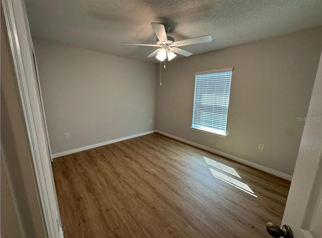 2467 Zuyder Terrace North Port, FL 34286 - Photo 8 of 14 an empty room with wooden floor fan and windows