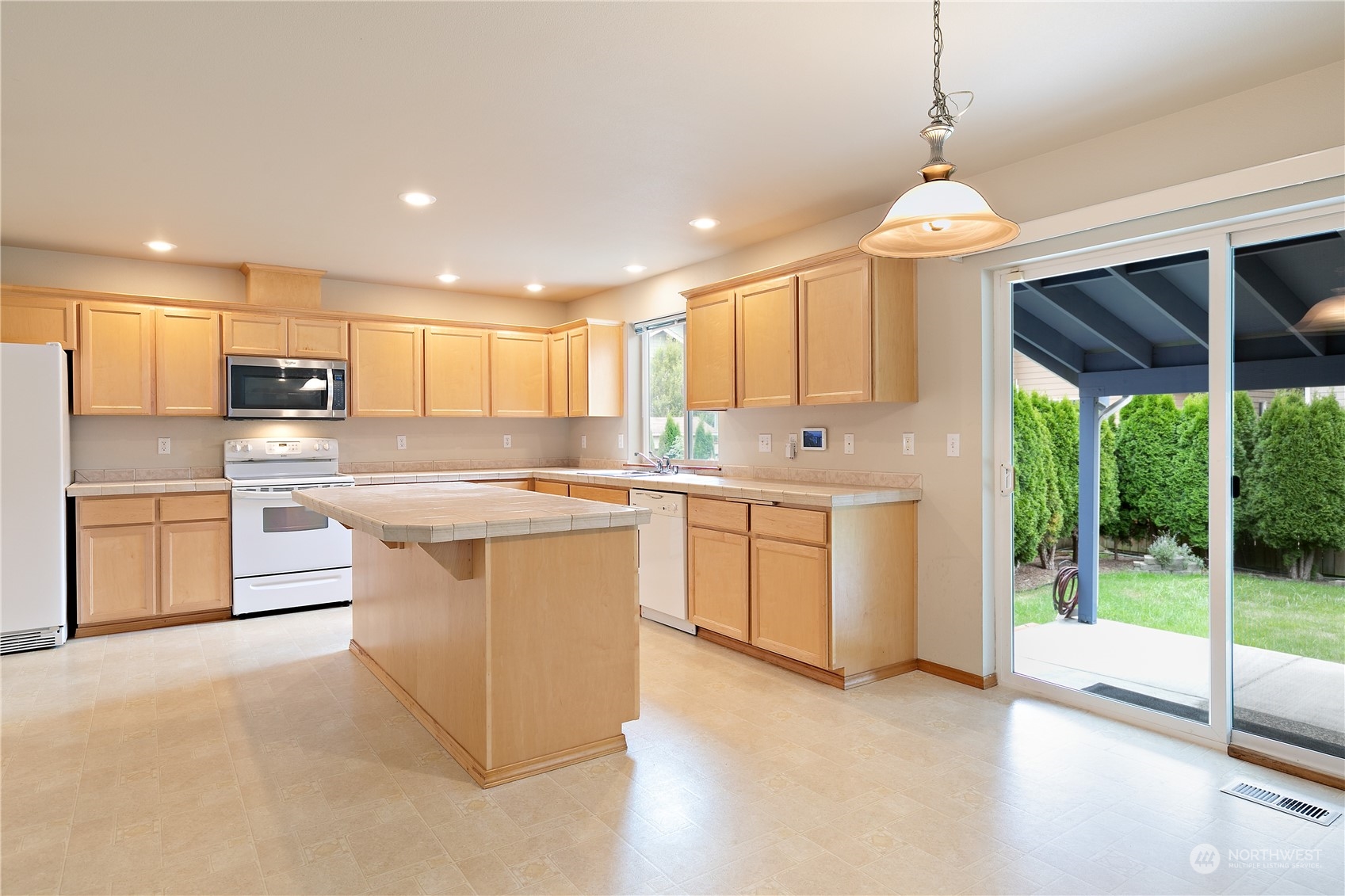 5209 Northeast 5th Court Renton, WA 98059 - Photo 6 of 28 a kitchen with stainless steel appliances granite countertop a sink a stove a refrigerator a washer dryer and white cabinets