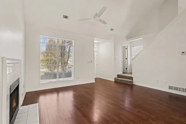 an empty room with wooden floor and windows