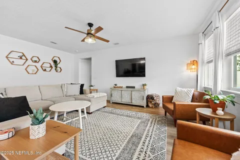 a living room with furniture kitchen view and a window