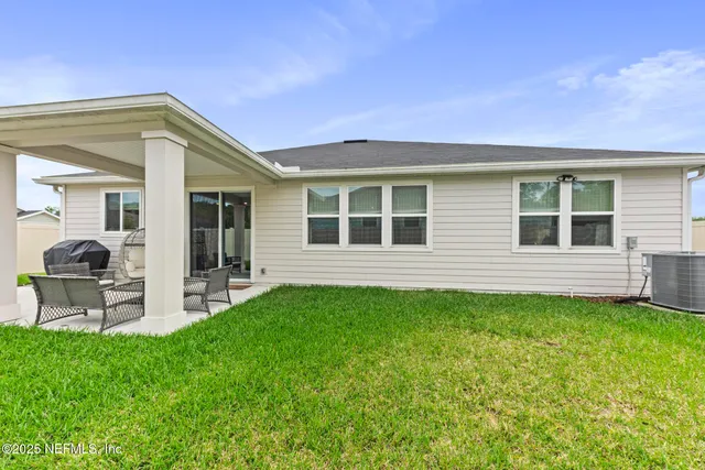 a backyard of a house with table and chairs