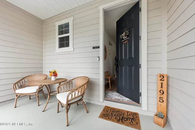 a view of a hallway with wooden floor and a bathroom