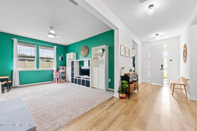 a view of a dining room and livingroom with furniture wooden floor a chandelier