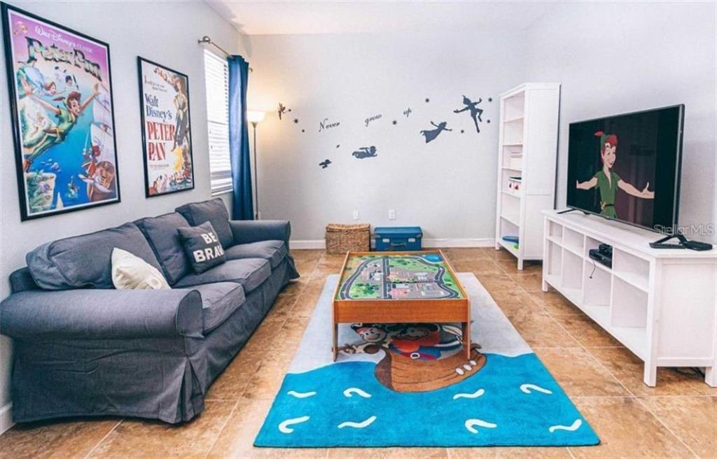 1427 Thunderbird Road Davenport, FL 33896 - Photo 11 of 52 a living room with furniture and a flat screen tv