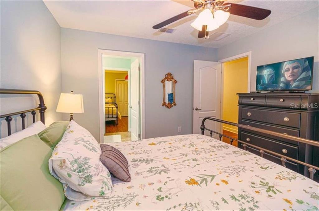 1427 Thunderbird Road Davenport, FL 33896 - Photo 20 of 52 a bedroom with a bed and a flat screen tv