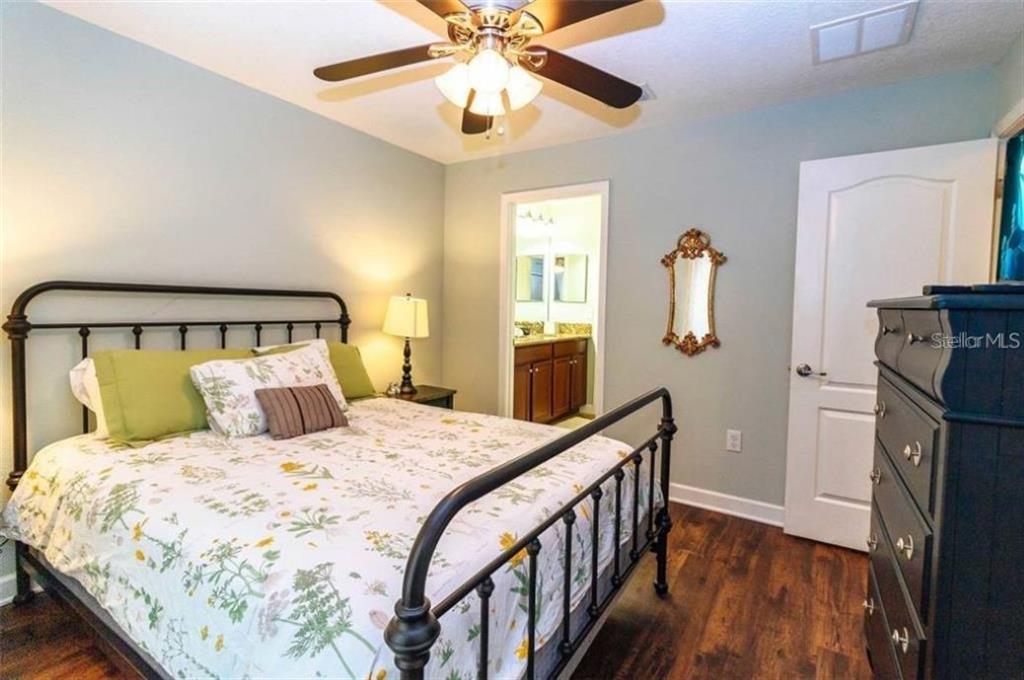 1427 Thunderbird Road Davenport, FL 33896 - Photo 23 of 52 a bedroom with a bed and a chandelier