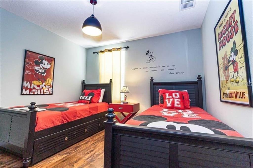 1427 Thunderbird Road Davenport, FL 33896 - Photo 29 of 52 a bedroom with a bed and wooden floor