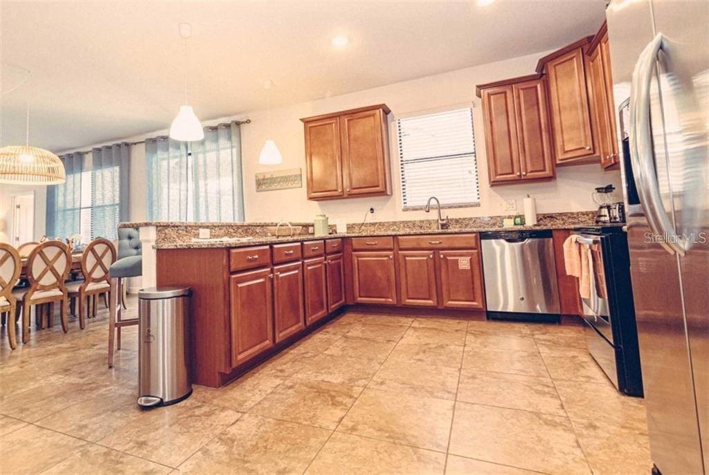 1427 Thunderbird Road Davenport, FL 33896 - Photo 9 of 52 a large kitchen with stainless steel appliances granite countertop a sink and cabinets