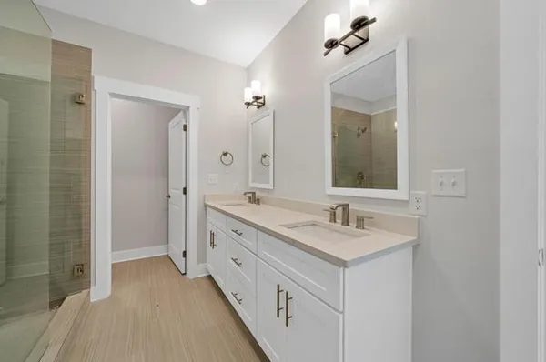 a bathroom with a double vanity sink a mirror and a shower