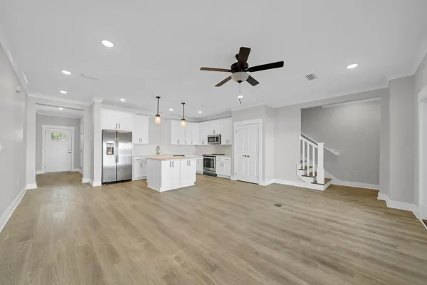 a view of an empty room with kitchen appliances and a window
