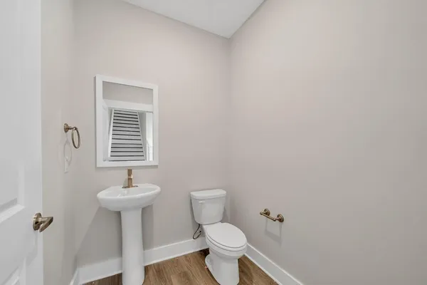 a bathroom with a sink toilet and a mirror