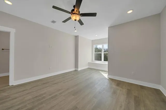 wooden floor in an empty room with a window