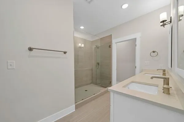 a bathroom with a shower sink vanity and mirror