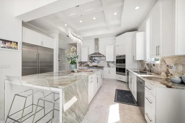 a large kitchen with kitchen island a sink stainless steel appliances and cabinets