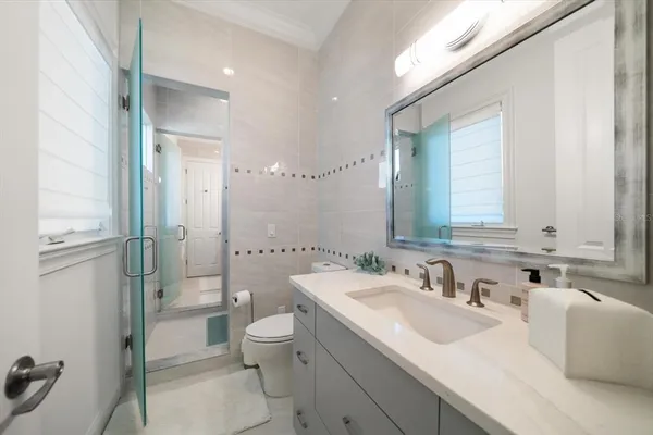 a bathroom with a sink toilet vanity and shower