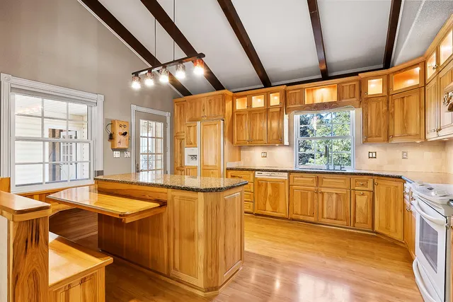 a large kitchen with stainless steel appliances granite countertop a sink and cabinets
