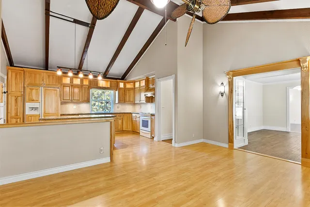 a large kitchen with granite countertop a lot of counter space and wooden floor