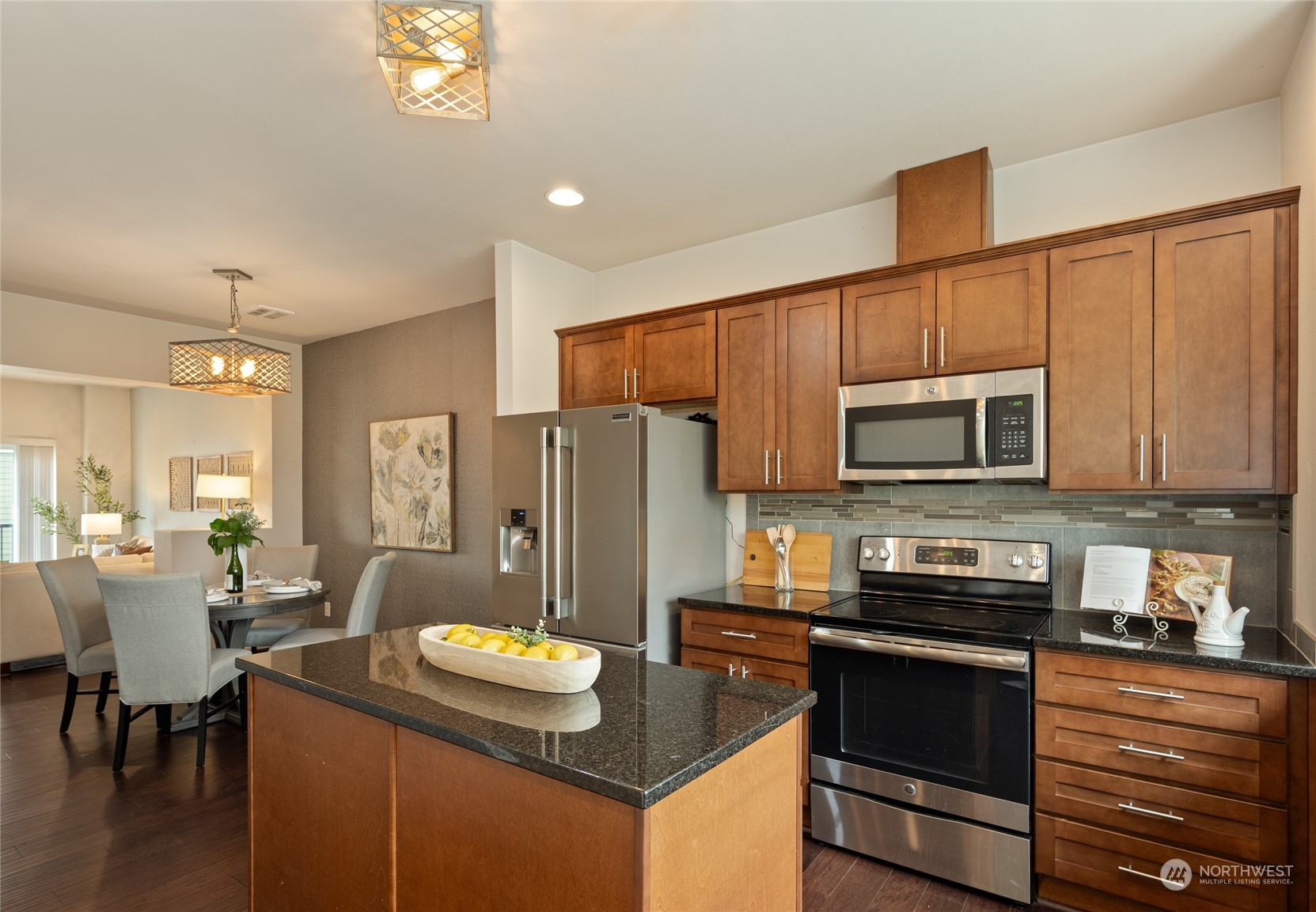 3312 31st Drive Everett, WA 98201 - Photo 7 of 27 a kitchen with stainless steel appliances granite countertop a refrigerator a stove top oven a sink dishwasher and dining table with wooden floor
