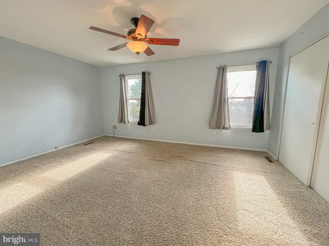 a view of a livingroom with a ceiling fan and window
