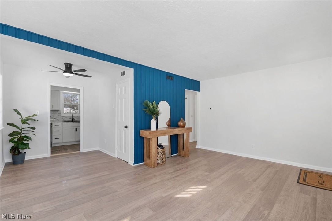2401 Greenvale Road Cleveland, OH 44121 - Photo 13 of 25 Unfurnished room with light wood-style floors and ceiling fan