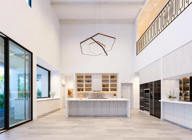 a living room with stainless steel appliances wooden floors and kitchen view