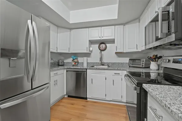 a kitchen with a refrigerator sink and cabinets