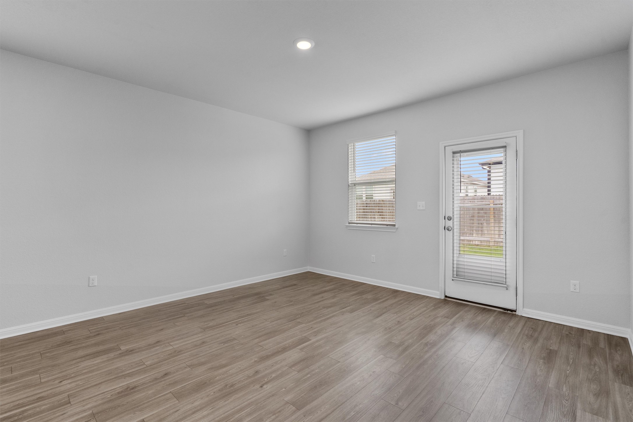 10613 Ridan Way Buda, TX 78610 - Photo 12 of 32 an empty room with wooden floor and windows