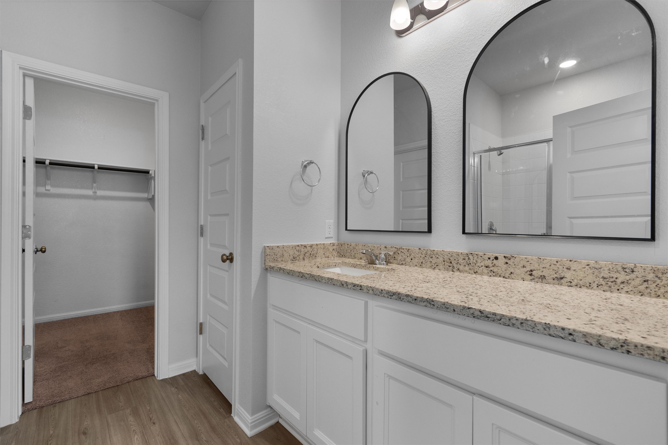 10613 Ridan Way Buda, TX 78610 - Photo 16 of 32 a bathroom with a granite countertop sink a mirror and a shower