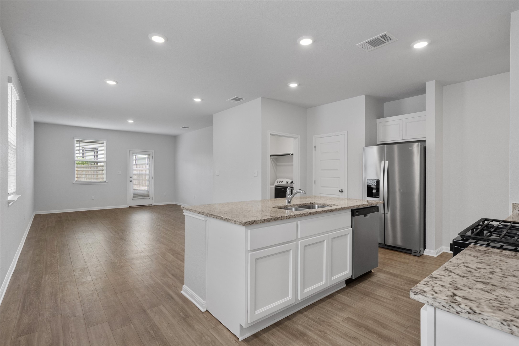 10613 Ridan Way Buda, TX 78610 - Photo 5 of 32 a kitchen with stainless steel appliances granite countertop a sink a stove a refrigerator cabinets and wooden floor