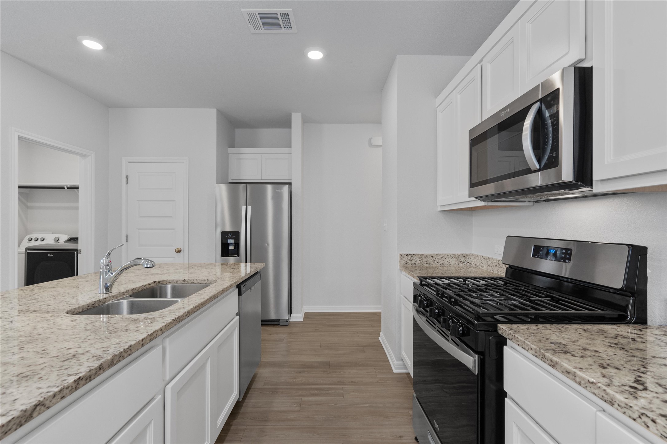 10613 Ridan Way Buda, TX 78610 - Photo 6 of 32 a kitchen with stainless steel appliances granite countertop a sink stove and refrigerator