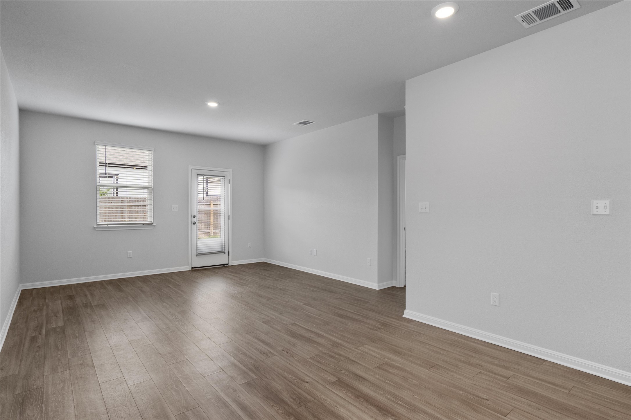 10613 Ridan Way Buda, TX 78610 - Photo 9 of 32 a view of an empty room with wooden floor and a window