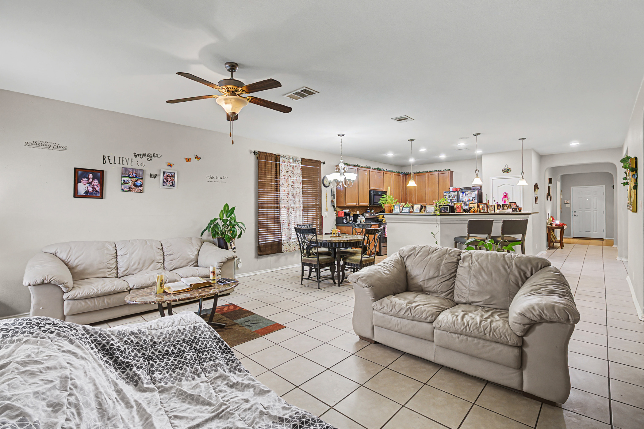 344 Matthews Kyle, TX 78640 - Photo 3 of 15 Living room featuring light tile patterned floors, a ceiling fan, arched walkways, and a chandelier
