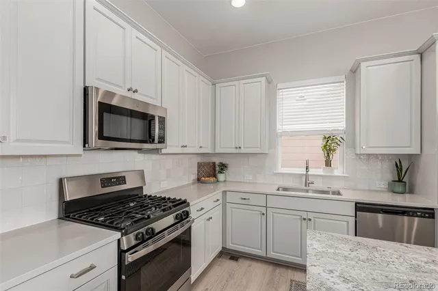 a kitchen with cabinets appliances a sink and a window