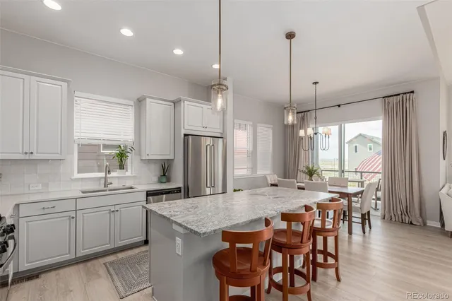 a view of a kitchen with kitchen island granite countertop a table and chairs in it