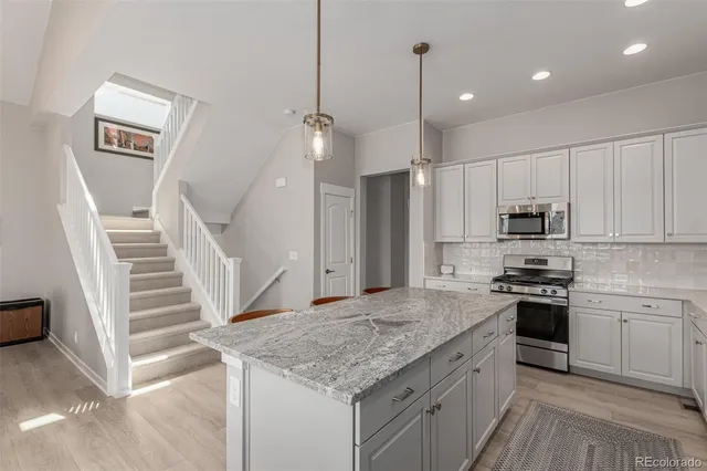 a kitchen with kitchen island a sink stainless steel appliances and cabinets