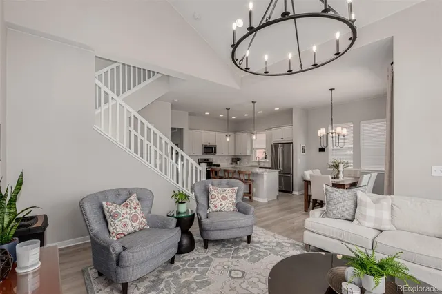 a living room with furniture chandelier and a mirror