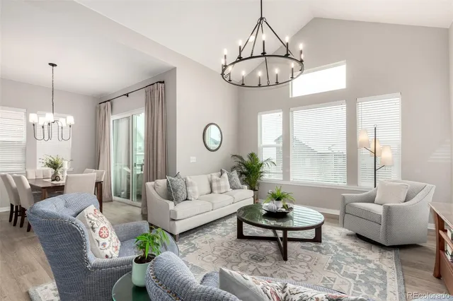 a living room with furniture chandelier and a large window